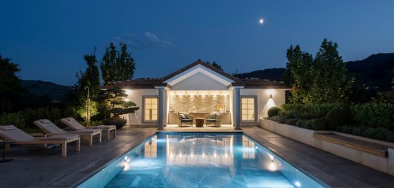 Das Bild zeigt ein Gegenstrompool mit gesenktem Hubboden von FlussPool bei Nacht und mit Unterwasserlicht beleuchtet. Die LED Scheinwerfer sorgen für ein stimmungsvolles Ambiente