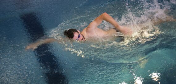 Es schwimmt ein Mann mit Schwimmbrille in einem Gegenstrompool von FlussPool.